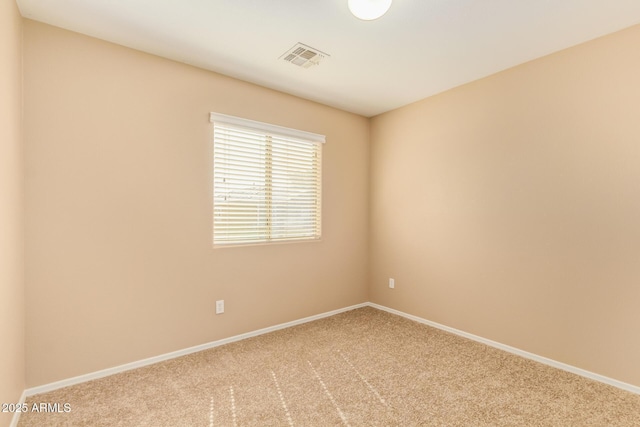 carpeted spare room featuring visible vents and baseboards