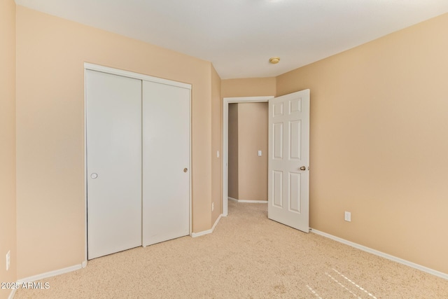 unfurnished bedroom featuring a closet, carpet flooring, and baseboards