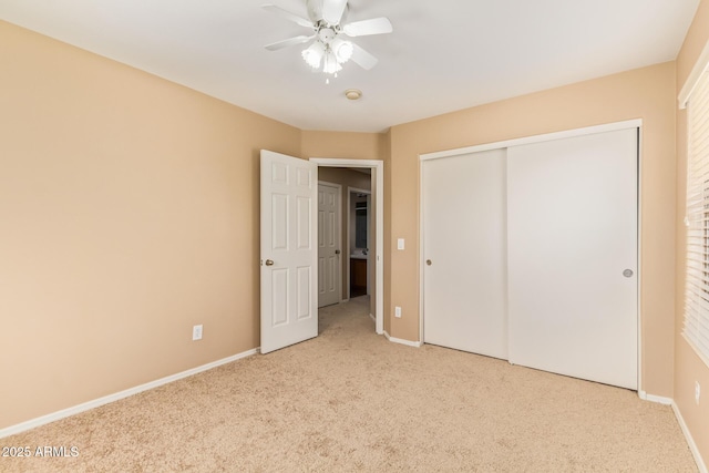 unfurnished bedroom with a closet, carpet flooring, ceiling fan, and baseboards