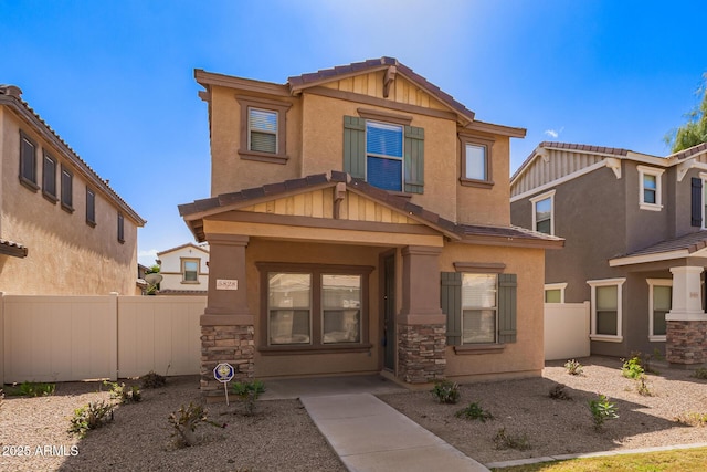 craftsman house featuring stone siding, stucco siding, and fence