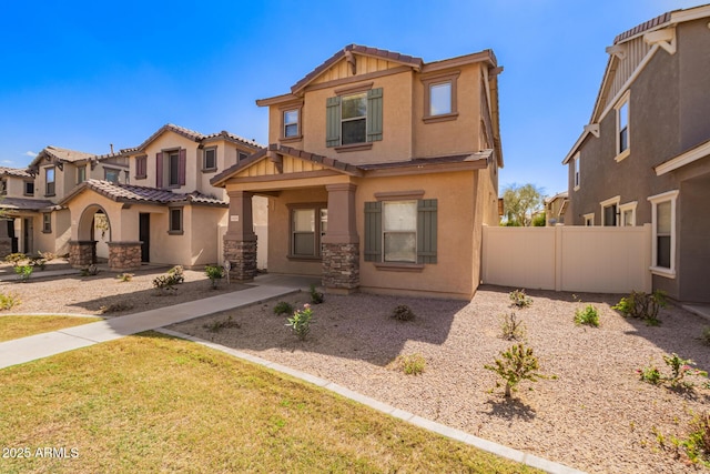 view of front of home with a tiled roof, stucco siding, stone siding, and fence