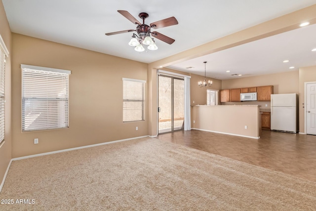 unfurnished living room with recessed lighting, ceiling fan with notable chandelier, baseboards, and carpet