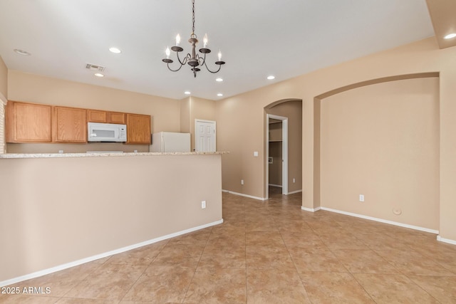 kitchen featuring white appliances, visible vents, baseboards, recessed lighting, and arched walkways