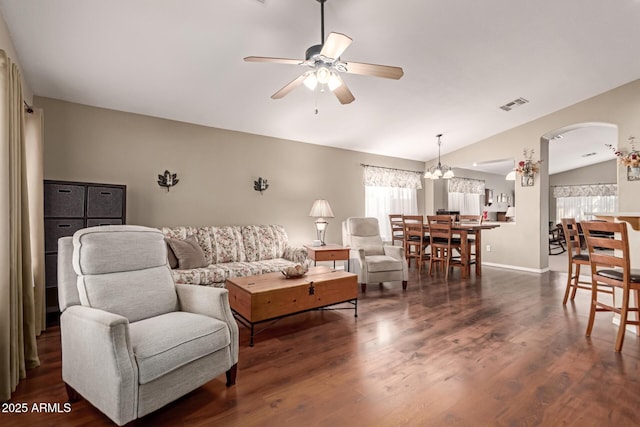 living room featuring lofted ceiling, dark wood-type flooring, and ceiling fan with notable chandelier