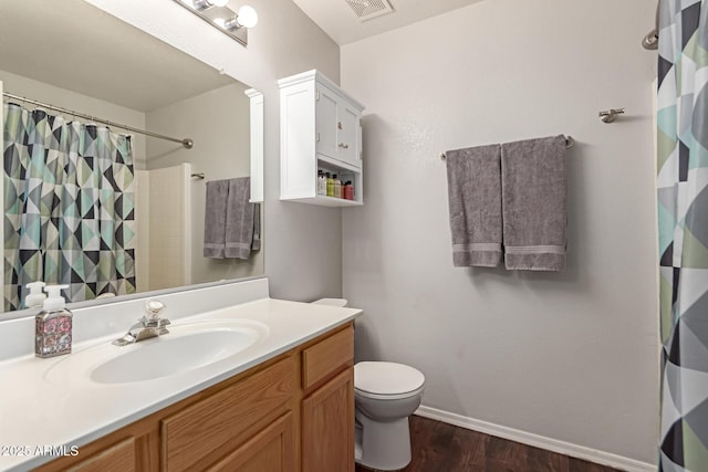 bathroom with walk in shower, hardwood / wood-style floors, vanity, and toilet