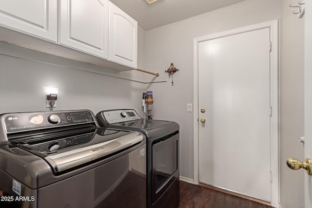 washroom with dark wood-type flooring, washer and dryer, and cabinets