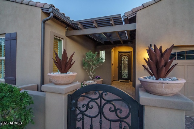 entrance to property featuring a tile roof and stucco siding