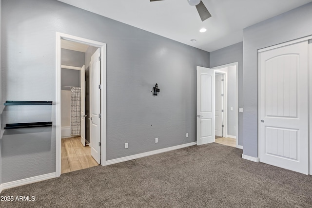 unfurnished bedroom with a closet, light colored carpet, ceiling fan, and ensuite bathroom