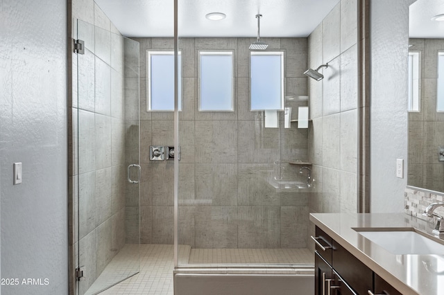 bathroom with vanity, tasteful backsplash, and an enclosed shower