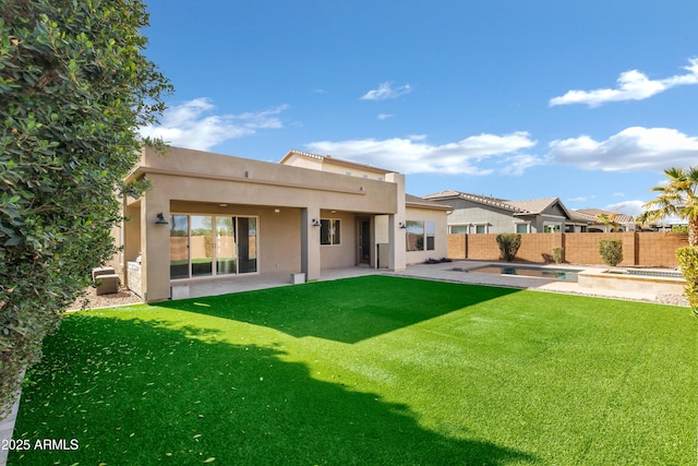 rear view of house with a swimming pool with hot tub, a patio area, and a yard