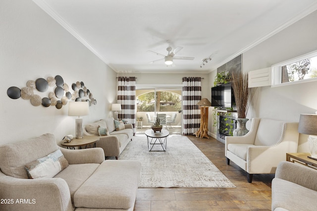 living room with plenty of natural light, crown molding, ceiling fan, and wood finished floors