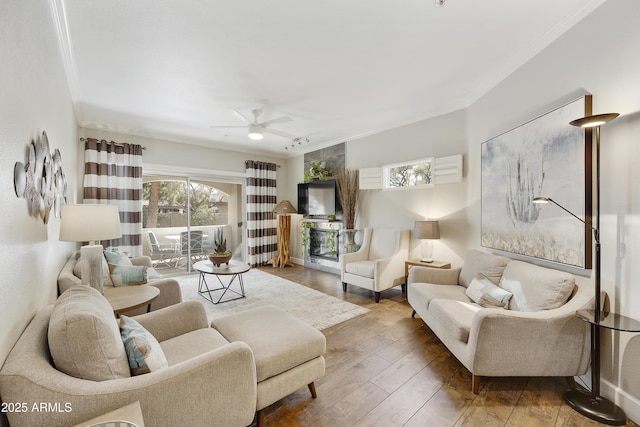 living room with crown molding, a ceiling fan, and wood-type flooring