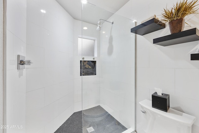 full bath with tile walls, toilet, and a walk in shower