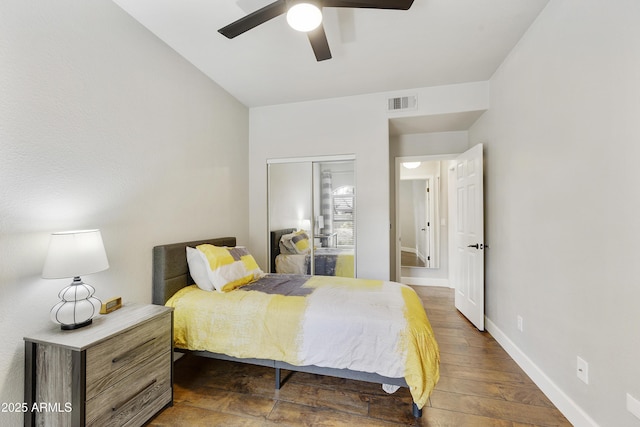 bedroom featuring a ceiling fan, baseboards, visible vents, dark wood-style flooring, and a closet