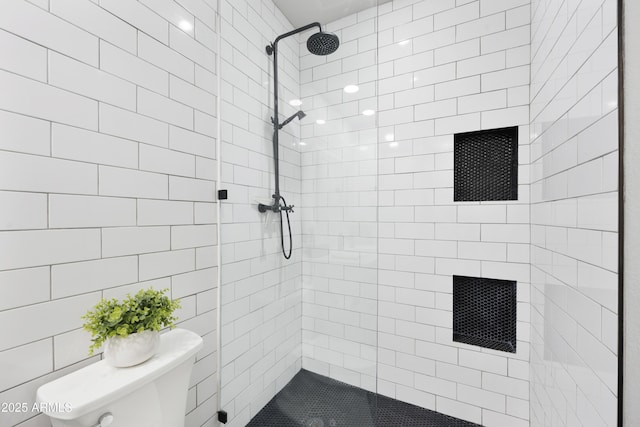 bathroom featuring toilet and tiled shower