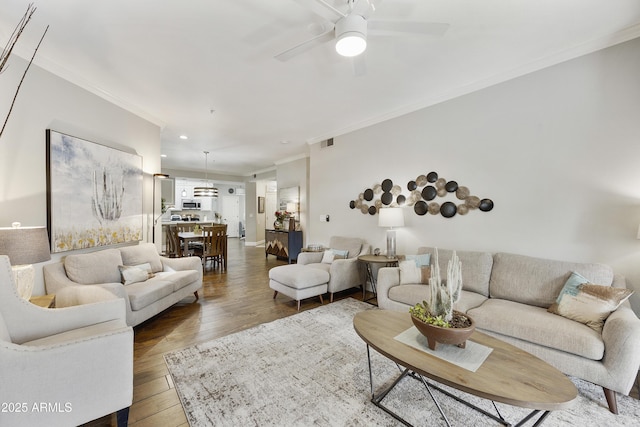 living area with visible vents, ornamental molding, recessed lighting, wood finished floors, and a ceiling fan