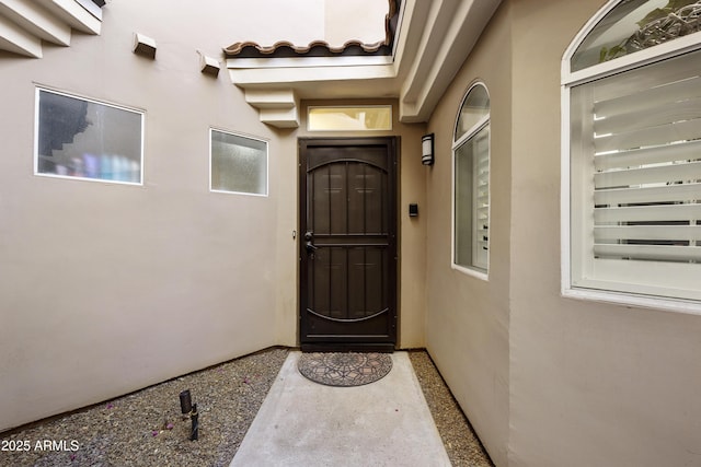 doorway to property featuring stucco siding