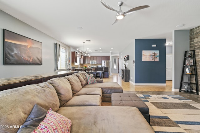 living area with recessed lighting, visible vents, baseboards, and ceiling fan with notable chandelier