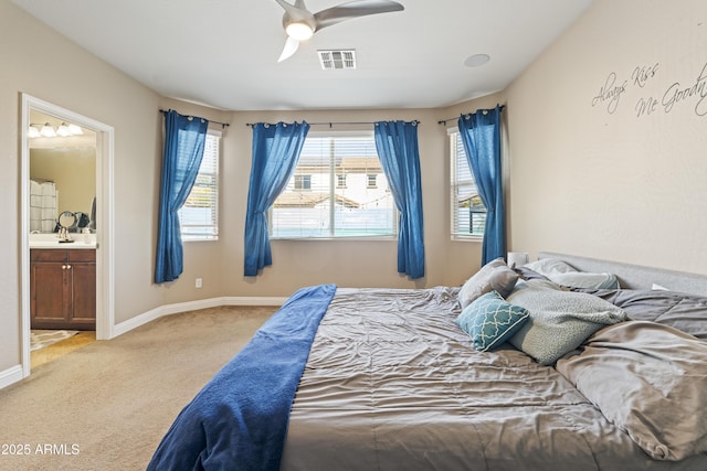 bedroom with ensuite bathroom, light colored carpet, a ceiling fan, baseboards, and visible vents