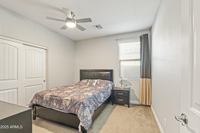 bedroom featuring baseboards, visible vents, light colored carpet, ceiling fan, and a closet