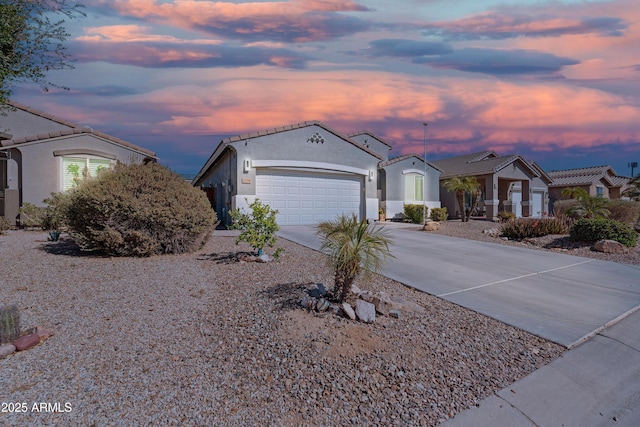 view of front of property featuring a garage, concrete driveway, and stucco siding