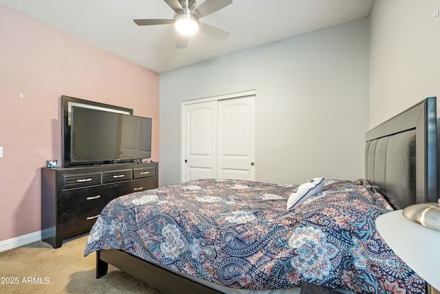 bedroom featuring light carpet, a ceiling fan, baseboards, and a closet