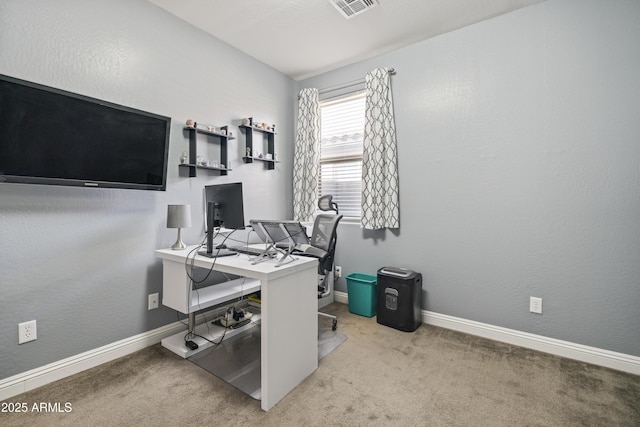 carpeted home office with a textured wall, visible vents, and baseboards