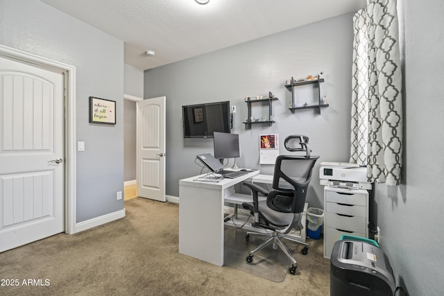 carpeted office space featuring a textured ceiling and baseboards