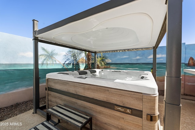 view of patio / terrace with a water view and a hot tub