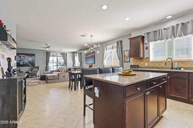 kitchen featuring tasteful backsplash, light tile patterned flooring, a sink, and visible vents