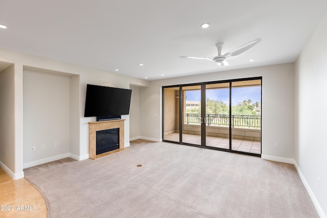 unfurnished living room with ceiling fan and light carpet