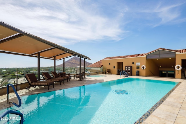 view of pool featuring a community hot tub, a mountain view, and a patio area