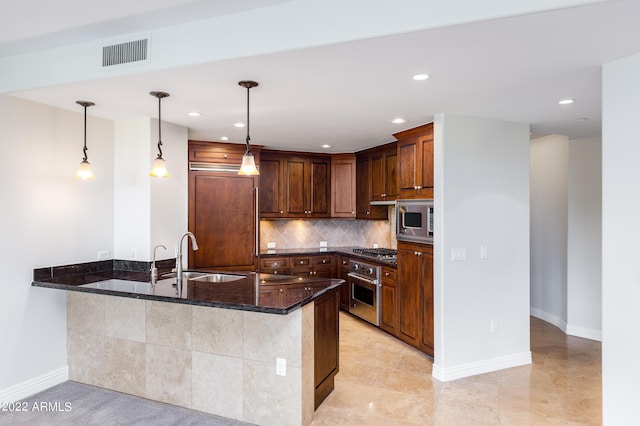 kitchen with dark stone countertops, appliances with stainless steel finishes, pendant lighting, and decorative backsplash