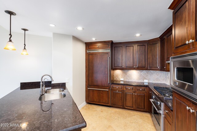 kitchen featuring tasteful backsplash, sink, hanging light fixtures, stainless steel appliances, and dark brown cabinets