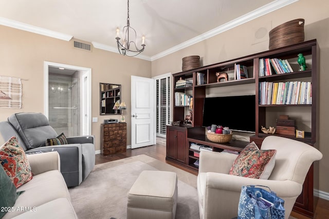 living room featuring an inviting chandelier, crown molding, and hardwood / wood-style flooring