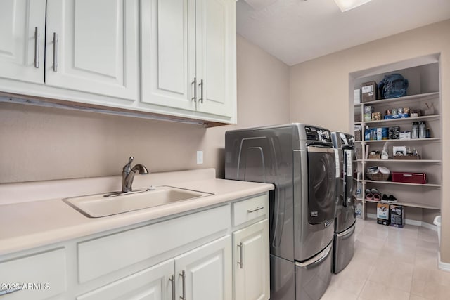 washroom featuring sink, washer and clothes dryer, cabinets, and light tile patterned flooring