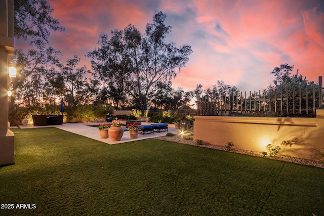 yard at dusk featuring an outdoor living space and a patio