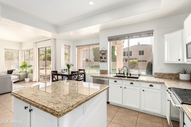 kitchen with light stone counters, appliances with stainless steel finishes, sink, and white cabinets