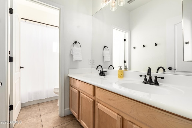 bathroom with tile patterned flooring, vanity, and toilet