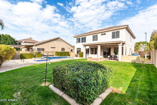 back of property featuring a fenced in pool, a patio, and a lawn