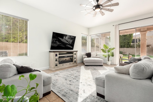 living room with ceiling fan, a fireplace, and light tile patterned floors