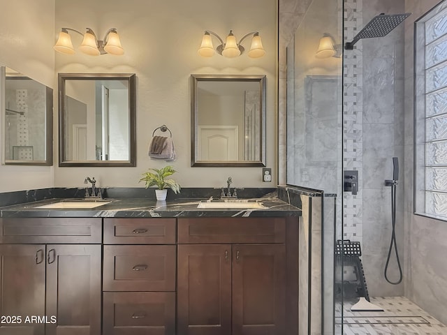 bathroom with tiled shower, a healthy amount of sunlight, and vanity