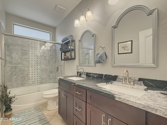 full bathroom featuring vanity, shower / bath combination with glass door, tile patterned floors, and toilet