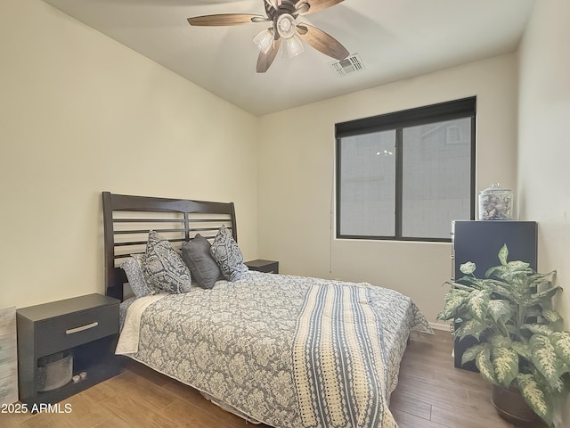 bedroom with dark hardwood / wood-style floors and ceiling fan