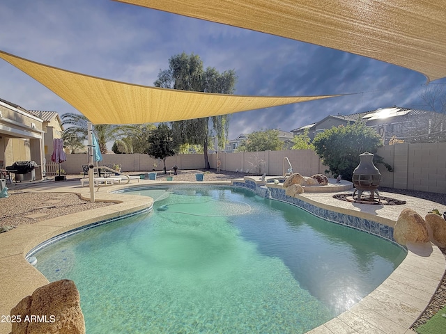 view of pool with a patio area, grilling area, and a fire pit