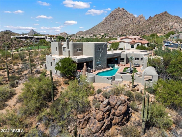 back of property with a patio and a mountain view