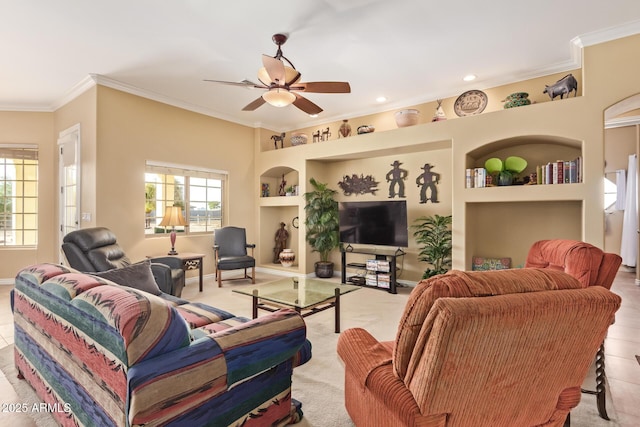 living area with built in features, ornamental molding, baseboards, and ceiling fan