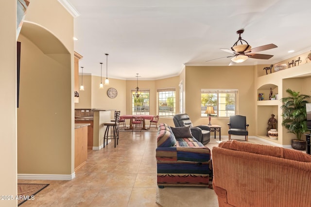 living room with light tile patterned floors, baseboards, ceiling fan, ornamental molding, and built in shelves