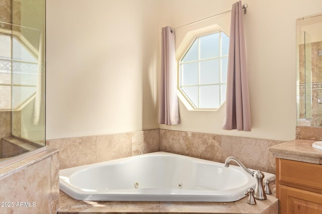 bathroom featuring a tub with jets and vanity