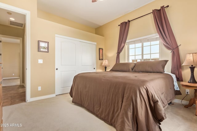 carpeted bedroom with baseboards, visible vents, and a closet